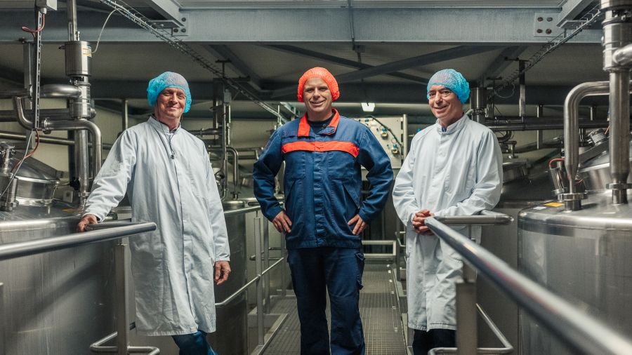 Drie mannen in een fabriek