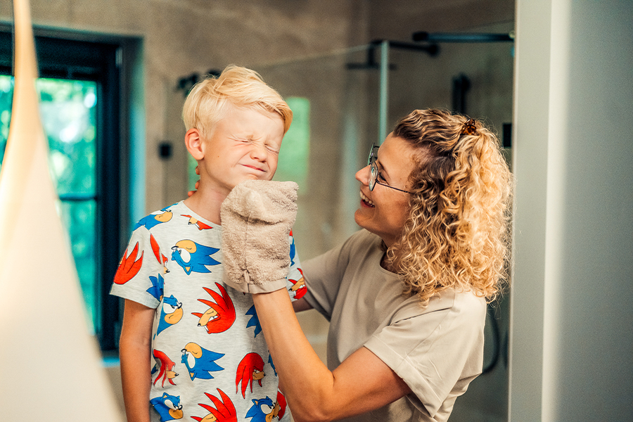 Moeder wast gezicht met washandje in de badkamer
