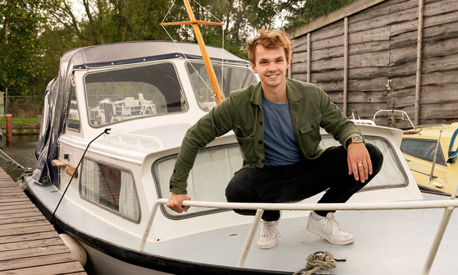Joost hurkend op zijn boot