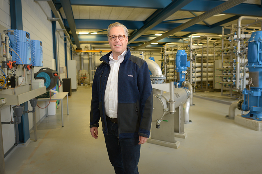 Man met Vitens-jas staat in productiebedrijf 