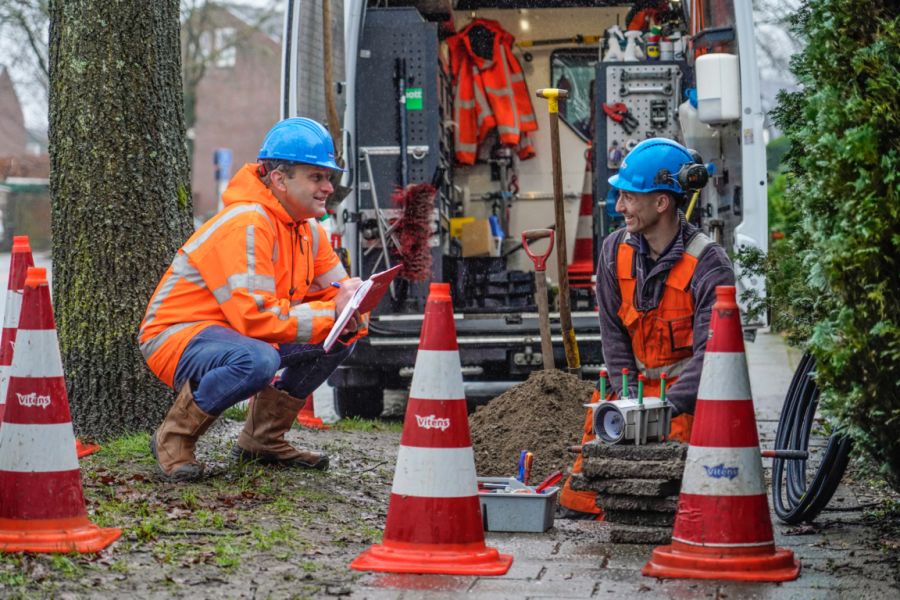 Twee medewerkers in gesprek over werkzaamheden aan de waterleiding