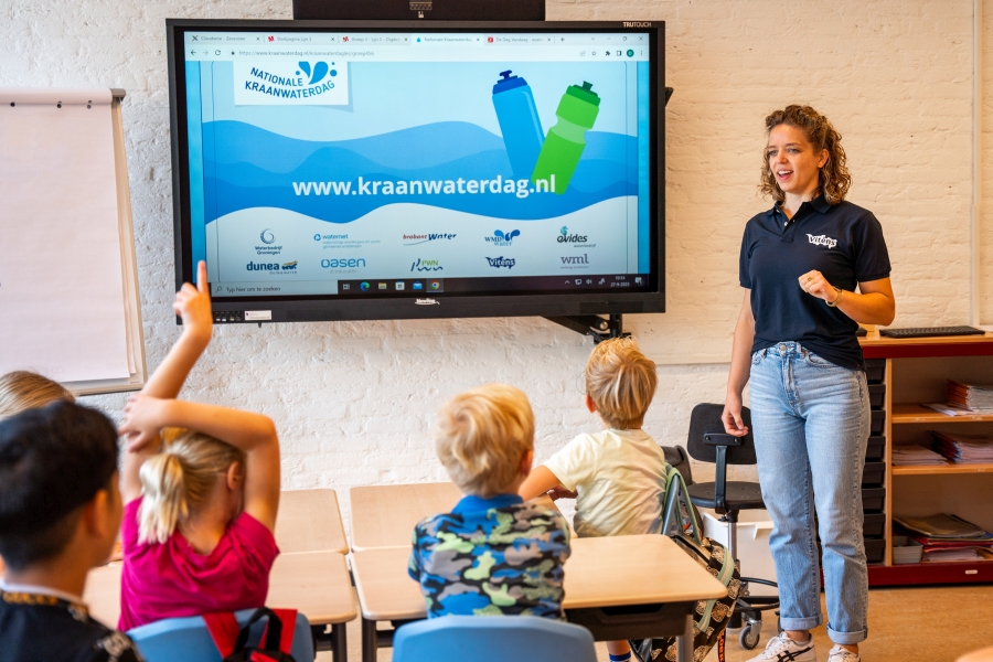 Collega van Vitens geeft les op een basisschool. 