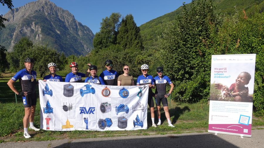 Mannen met fietshelm poseren met banner voor Water for Life