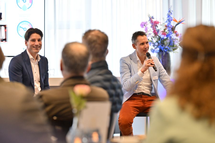 Twee mannen vertellen een verhaal aan een groot publiek