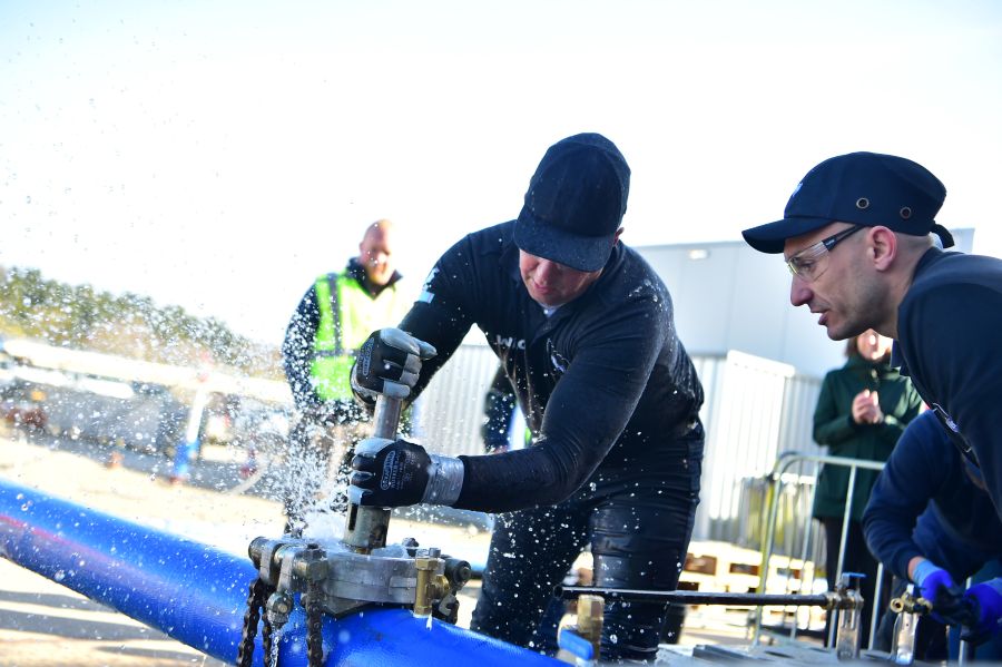 Twee mannen die bezig zijn met een buis te fitten.