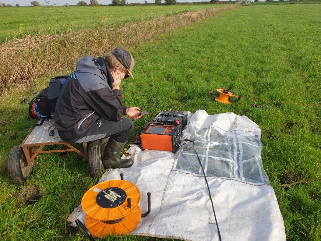 Een persoon die veldonderzoek doet op een weiland