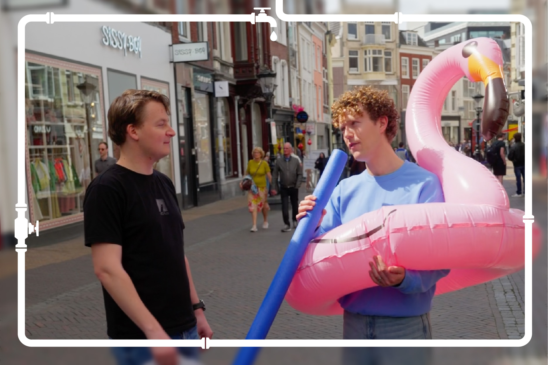 Man staat in een straat en interviewt een andere man